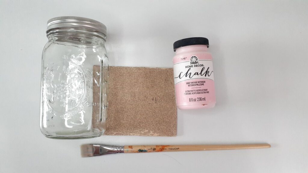 Supplies are a mason jar, chalk paint, paint brush, and sandpaper
