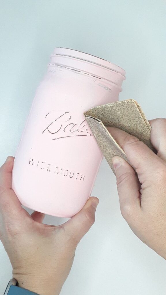 Use the sandpaper to distress the painted mason jar. 